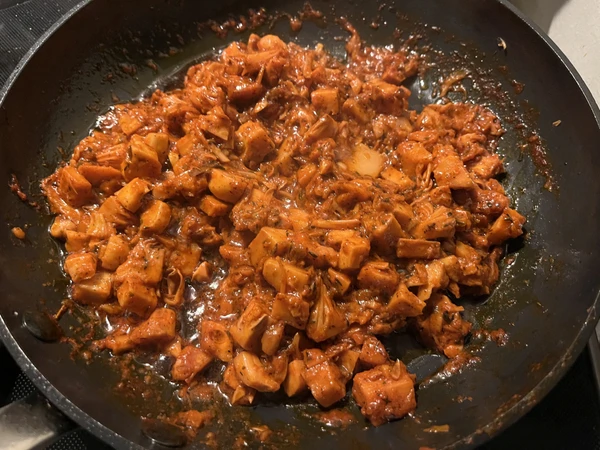 Jackfruit in the pan with achiote sauce as it cooks down before being served as tacos.
