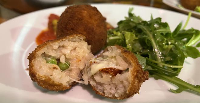 Arancini on a plate with some salad