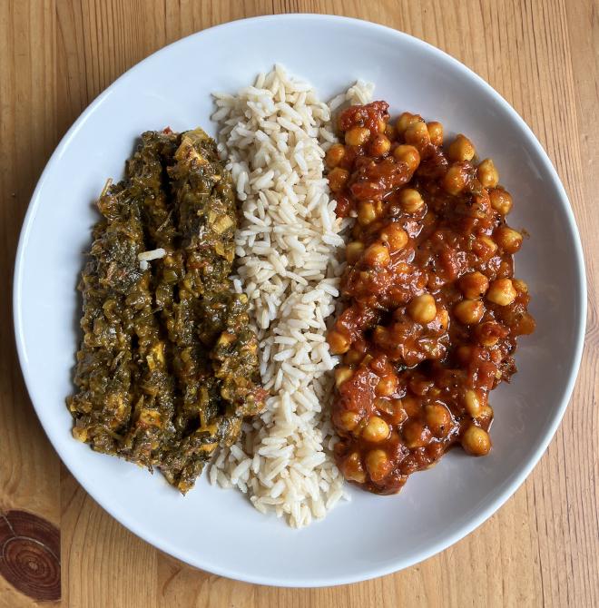 A plate of chana masala and palak paneer, served with rice.