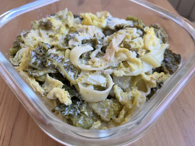 A glass bowl of pasta with savoy cabbage-lemon cream sauce