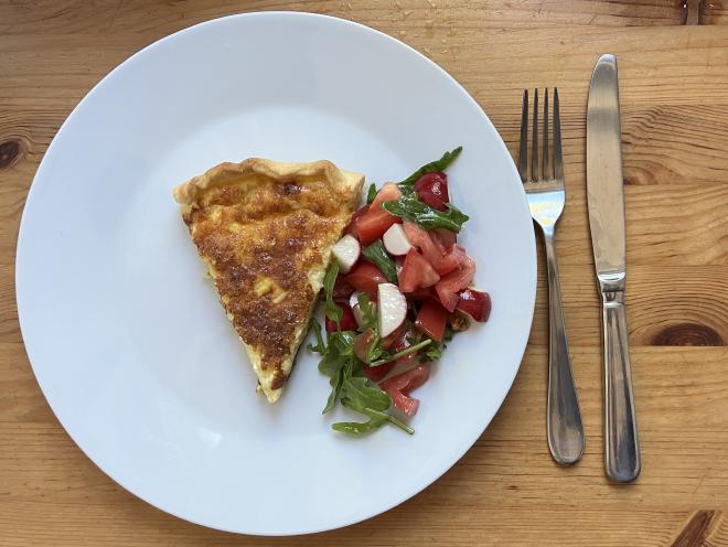 A slice of savory cheesecake with salad.