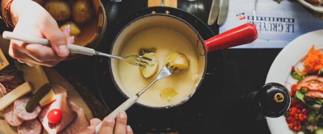 A caquelon with fondue and garnishes